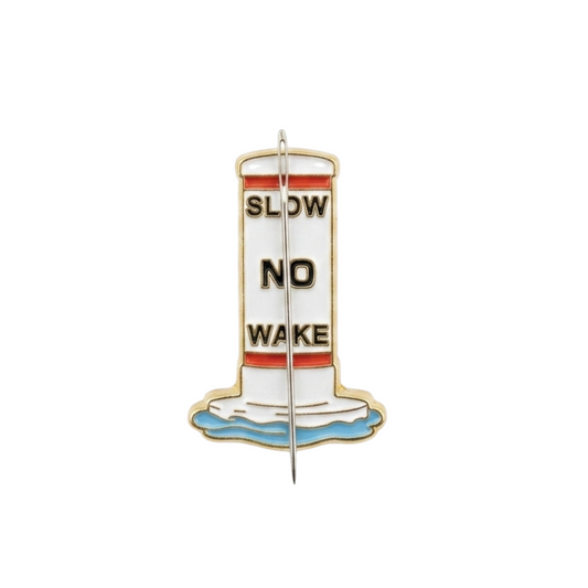 Close up of slow no way buoy enamel needle minder with hard enamel finish and metal edging.