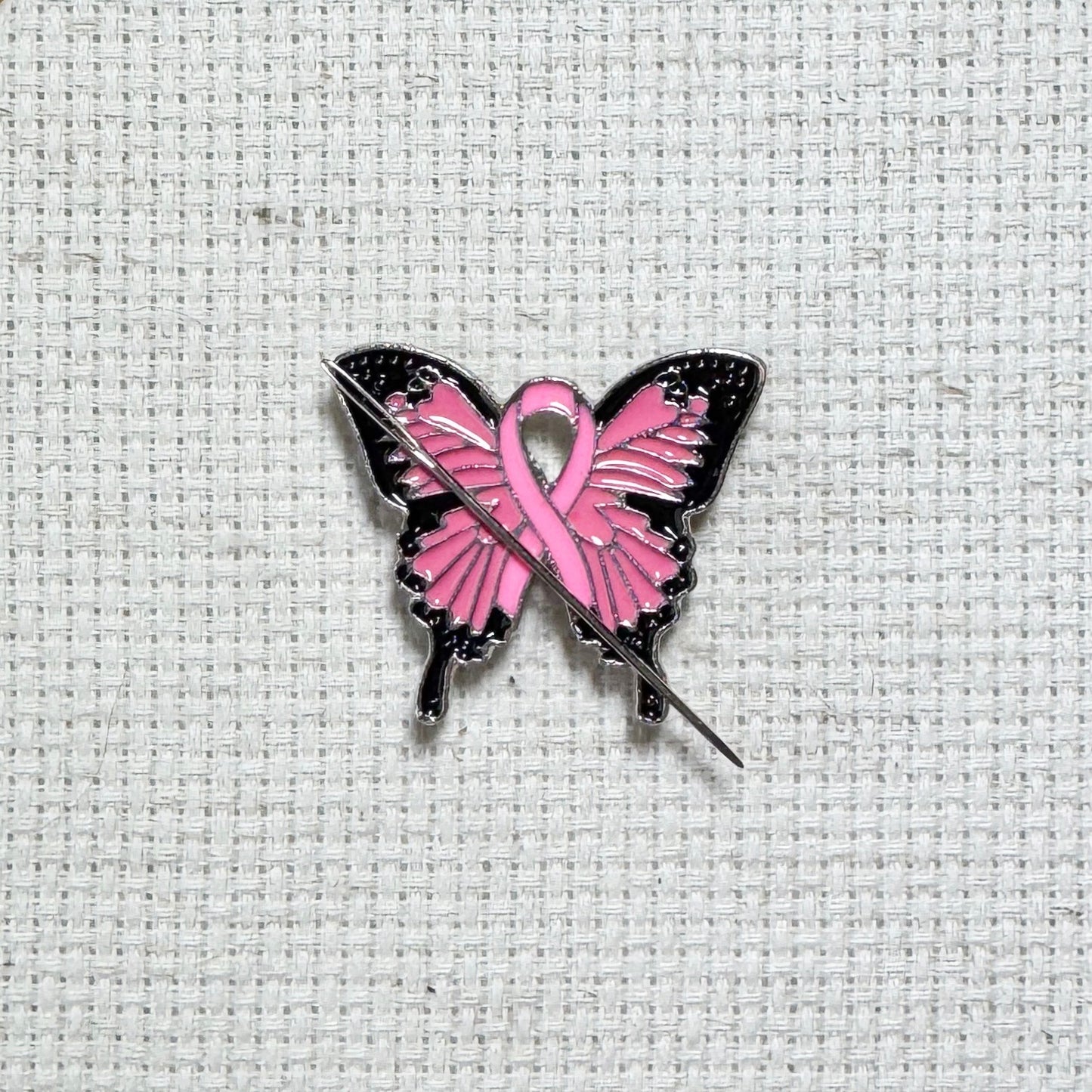 Butterfly Pink Ribbon magnetic enamel needle minder – a meaningful needle holder for cross stitch, embroidery, sewing, quilting, or needlepoint. Show your support and raise breast cancer awareness with every stitch.