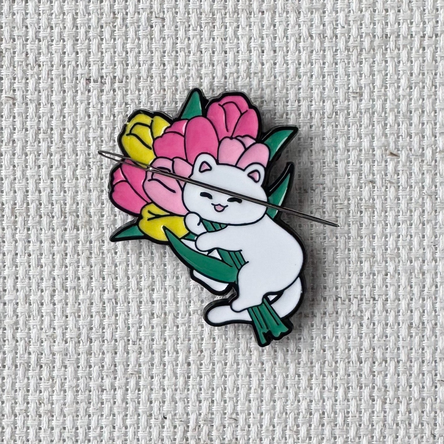 White cat holding pink and yellow tulips needle minder – magnetic enamel holder for cross stitch, embroidery, needlepoint or sewing.