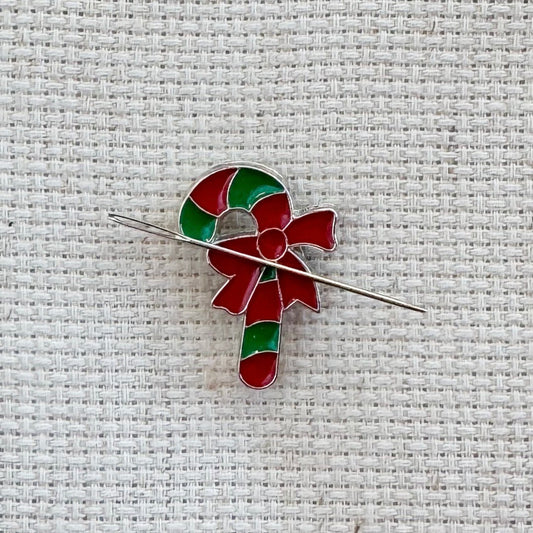 Green and red candy cane magnetic needle minder – festive enamel accessory for cross stitch, embroidery, and needlepoint – holiday stitching gift with classic Christmas candy design.