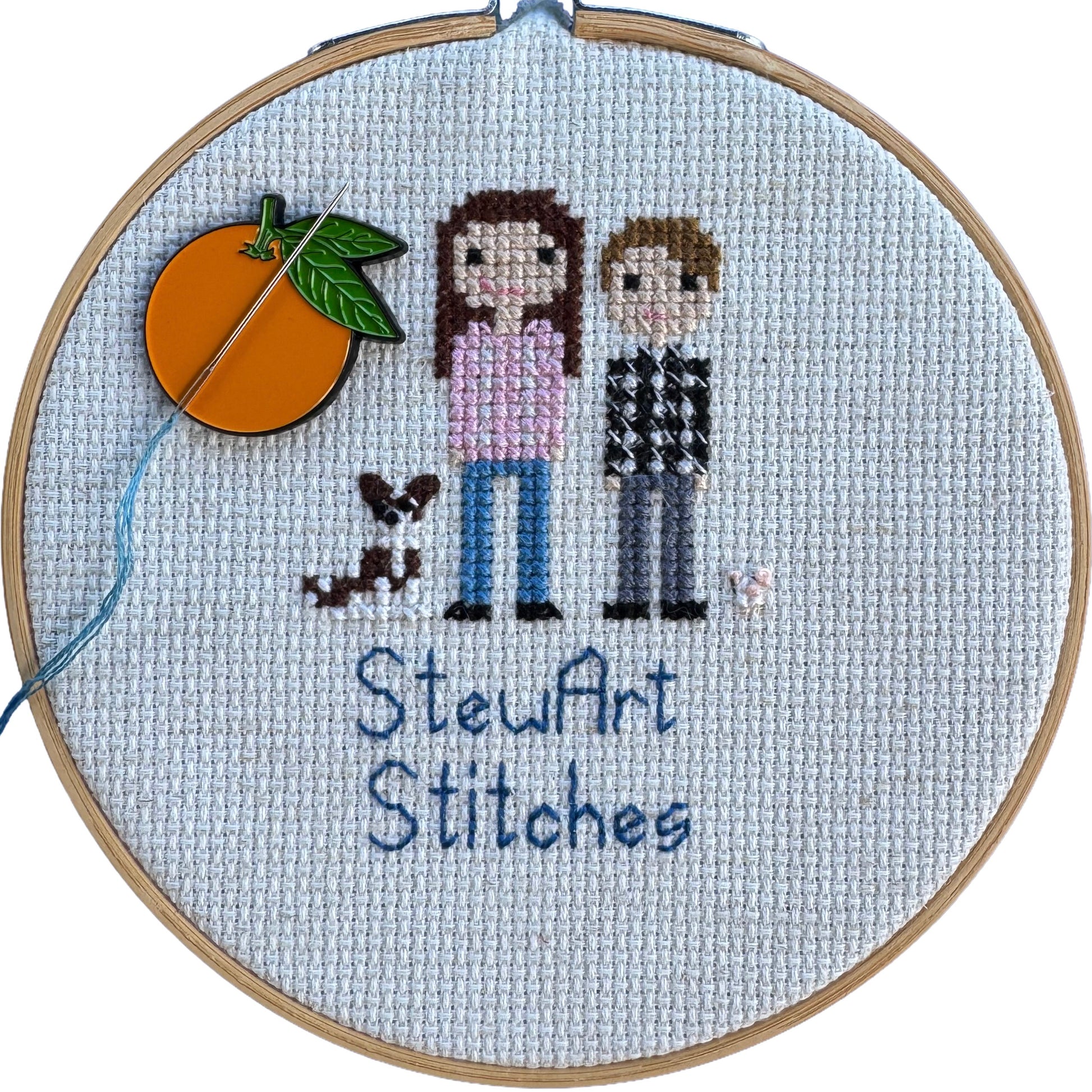 Orange needle minder holding a needle on a needlepoint canvas while stitching.