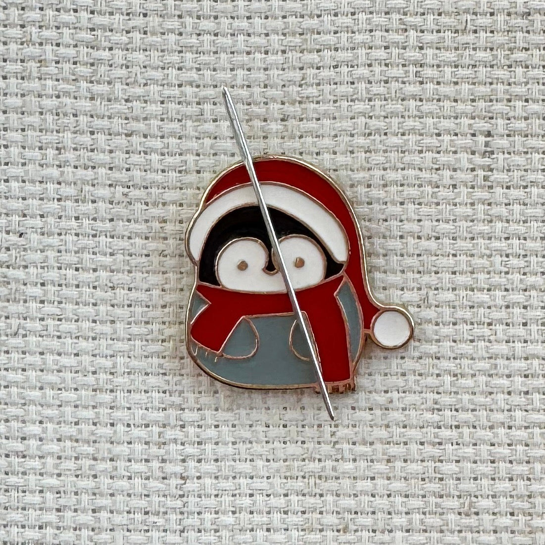 Penguin in Santa hat magnetic needle minder – cute enamel accessory for cross stitch, embroidery, and needlepoint – festive winter stitching gift for holiday crafters.