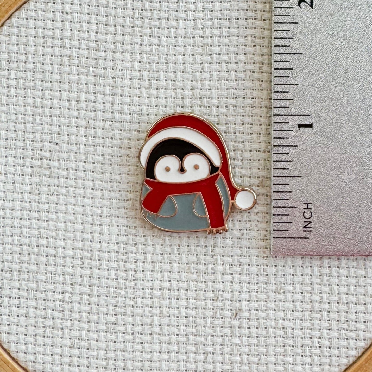 Penguin in Santa hat magnetic needle minder – cute enamel accessory for cross stitch, embroidery, and needlepoint – festive winter stitching gift for holiday crafters.