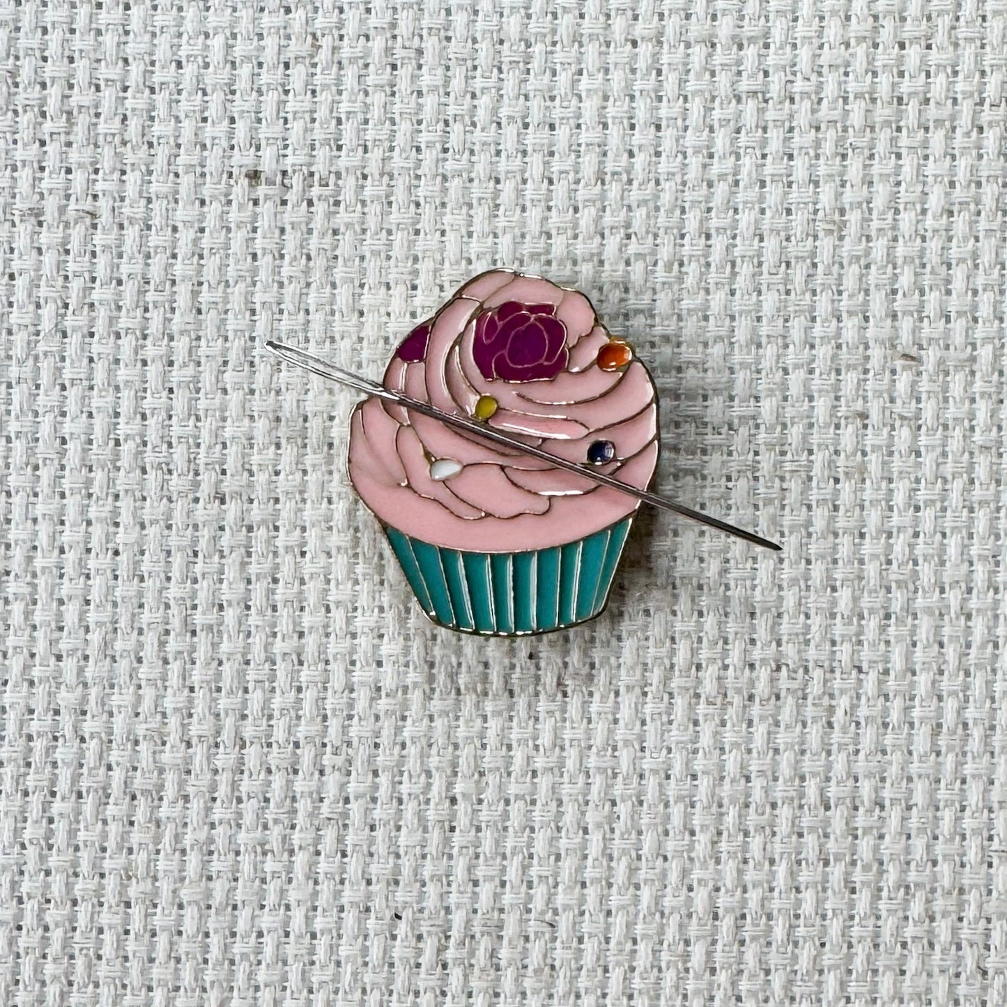 Pink cupcake magnetic needle minder – sweet enamel accessory for cross stitch, embroidery, and needlepoint – cute dessert themed stitching gift for bakers and cupcake lovers.