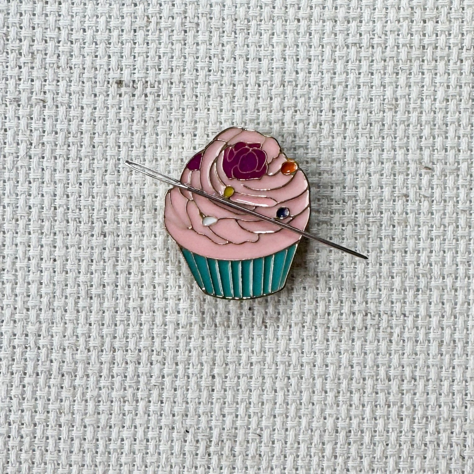 Pink cupcake magnetic needle minder – sweet enamel accessory for cross stitch, embroidery, and needlepoint – cute dessert themed stitching gift for bakers and cupcake lovers.