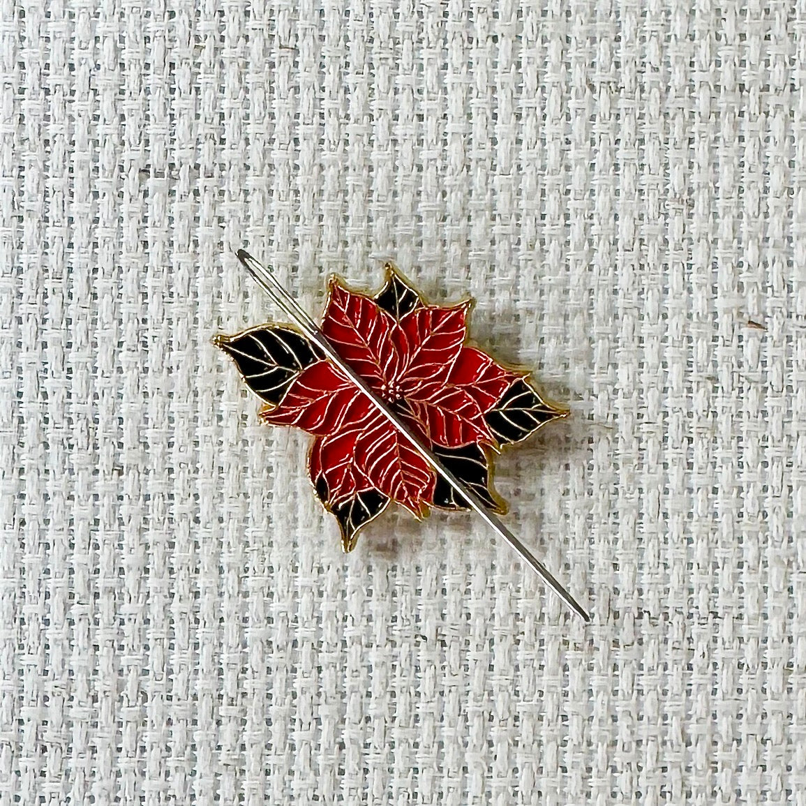 Poinsettia Enamel Magnetic Needle Minder — add a festive floral touch to your cross stitch, embroidery, needlepoint, quilting, or hand sewing! A merry and bright needle holder for every stitcher and crafter.