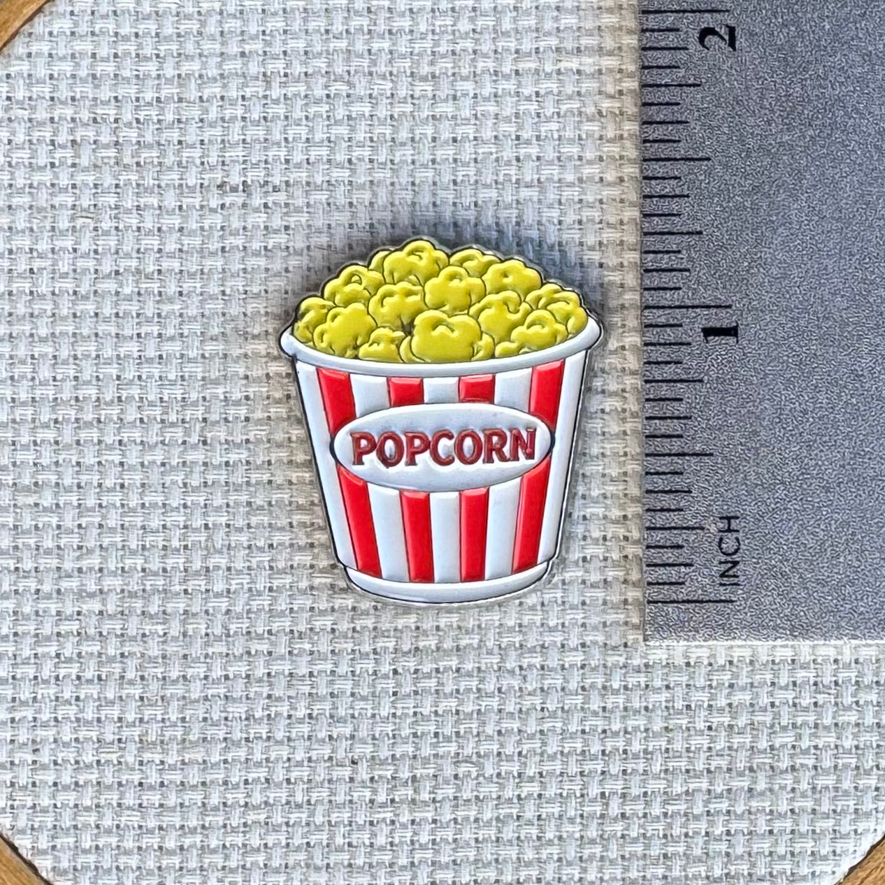 Popcorn needle minder shown with ruler for size measurement, approximately 1.25 inch needle minder.