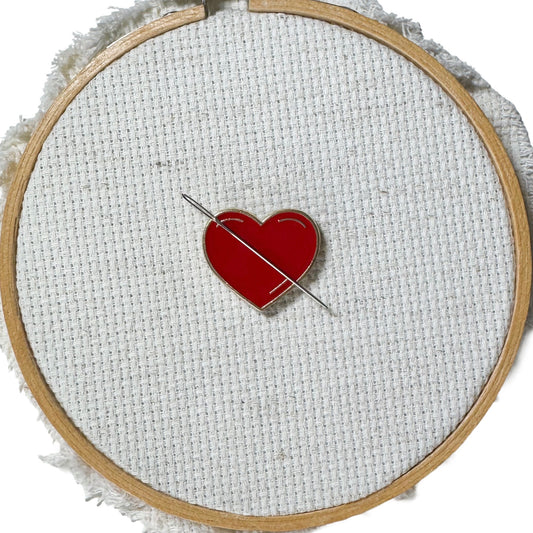 Red heart shaped magnetic enamel needle minder for cross stitch, embroidery, needlepoint and sewing projects.