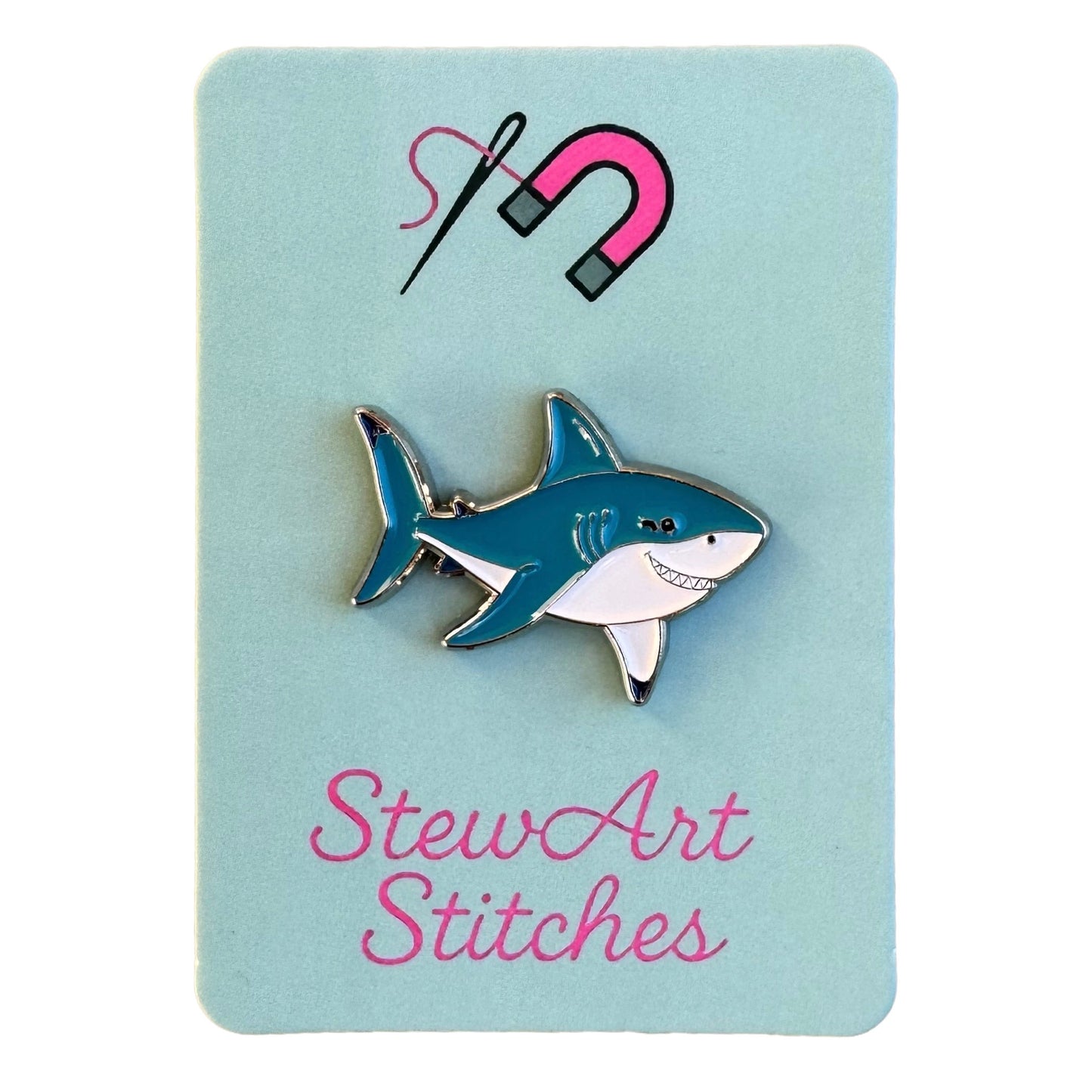 Shark magnetic enamel needle minder displayed on product packaging card for StewArt Stitches.