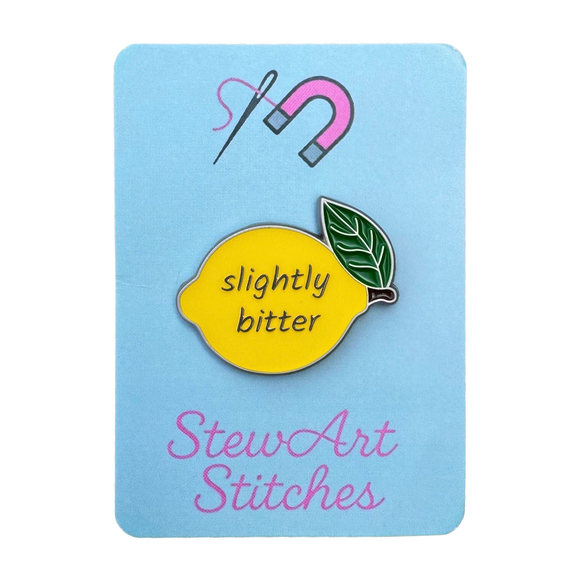 Slightly bitter lemon magnetic enamel needle minder displayed on product packaging card for StewArt Stitches.