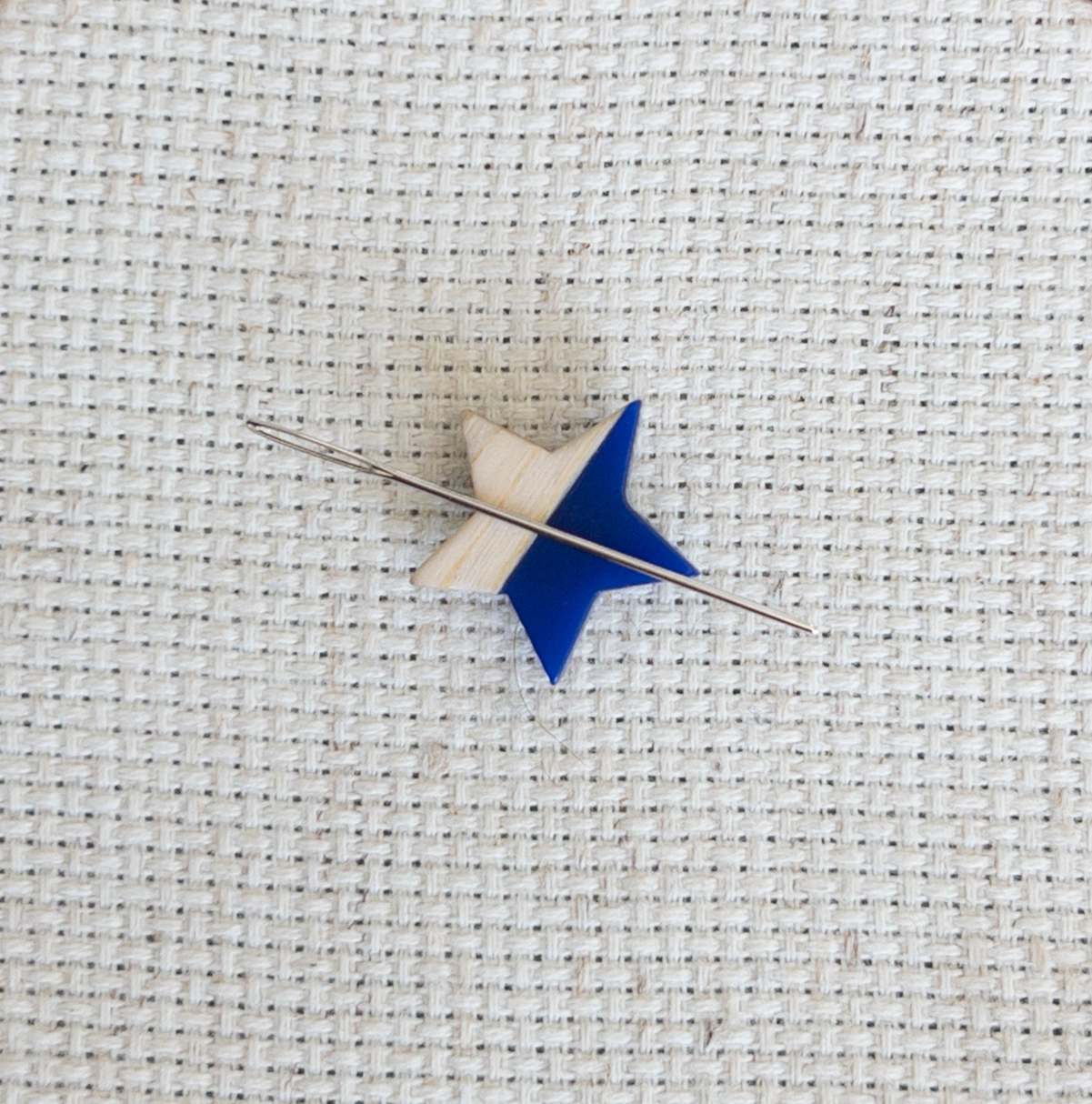 Star shaped magnetic needle minder with blue resin and natural wood – ideal for cross stitch, embroidery, needlepoint, quilting, and hand sewing. A unique and functional needle holder for stitchers and crafters.