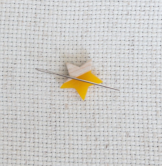 Star shaped magnetic needle minder with yellow resin and natural wood – ideal for cross stitch, embroidery, needlepoint, quilting, and hand sewing. A unique and functional needle holder for stitchers and crafters.