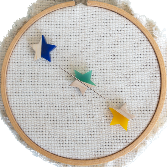 Set of 3 star shaped magnetic needle minders with blue, green and yellow resin and natural wood – ideal for cross stitch, embroidery, needlepoint, quilting, and hand sewing. A unique and functional needle holder for stitchers and crafters.