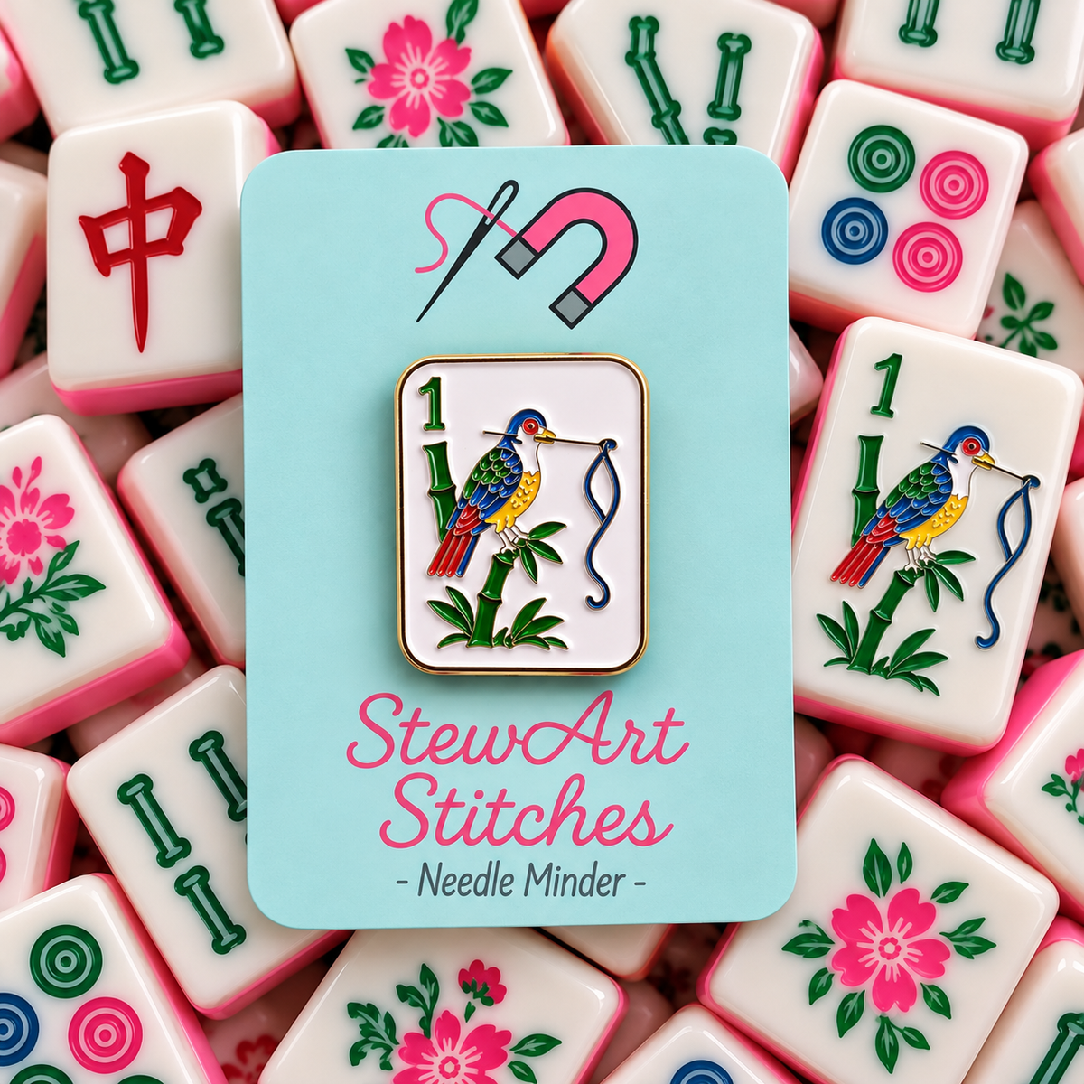 Birdie Bam mahjong tile needle minder featuring a colorful bird design enamel needle minder with gold color trim, magnetic accessory for cross stitch, needlepoint, embroidery, quilting and sewing.
