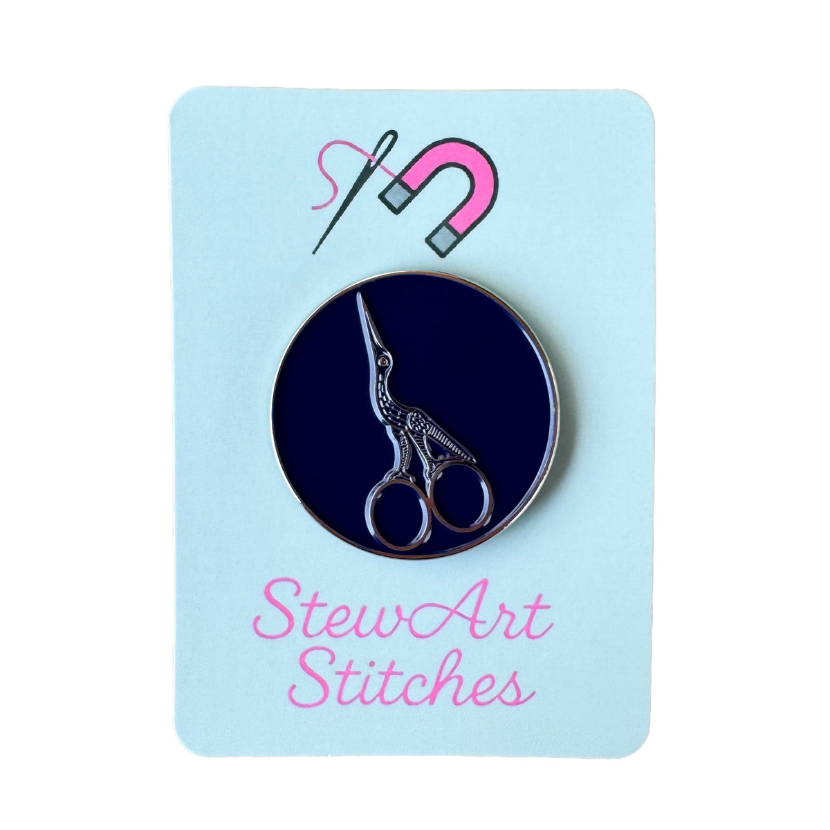 Stork scissors needle minder displayed on product packaging card for StewArt Stitches.