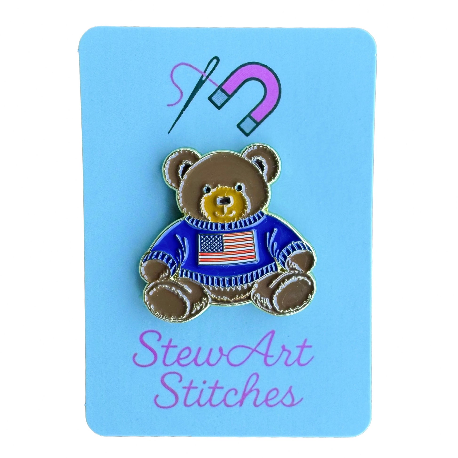 Teddy bear enamel needle minder wearing a blue sweater with an American flag, magnetic needle holder for cross stitch, needlepoint, embroidery, quilting, sewing and other stitching projects.