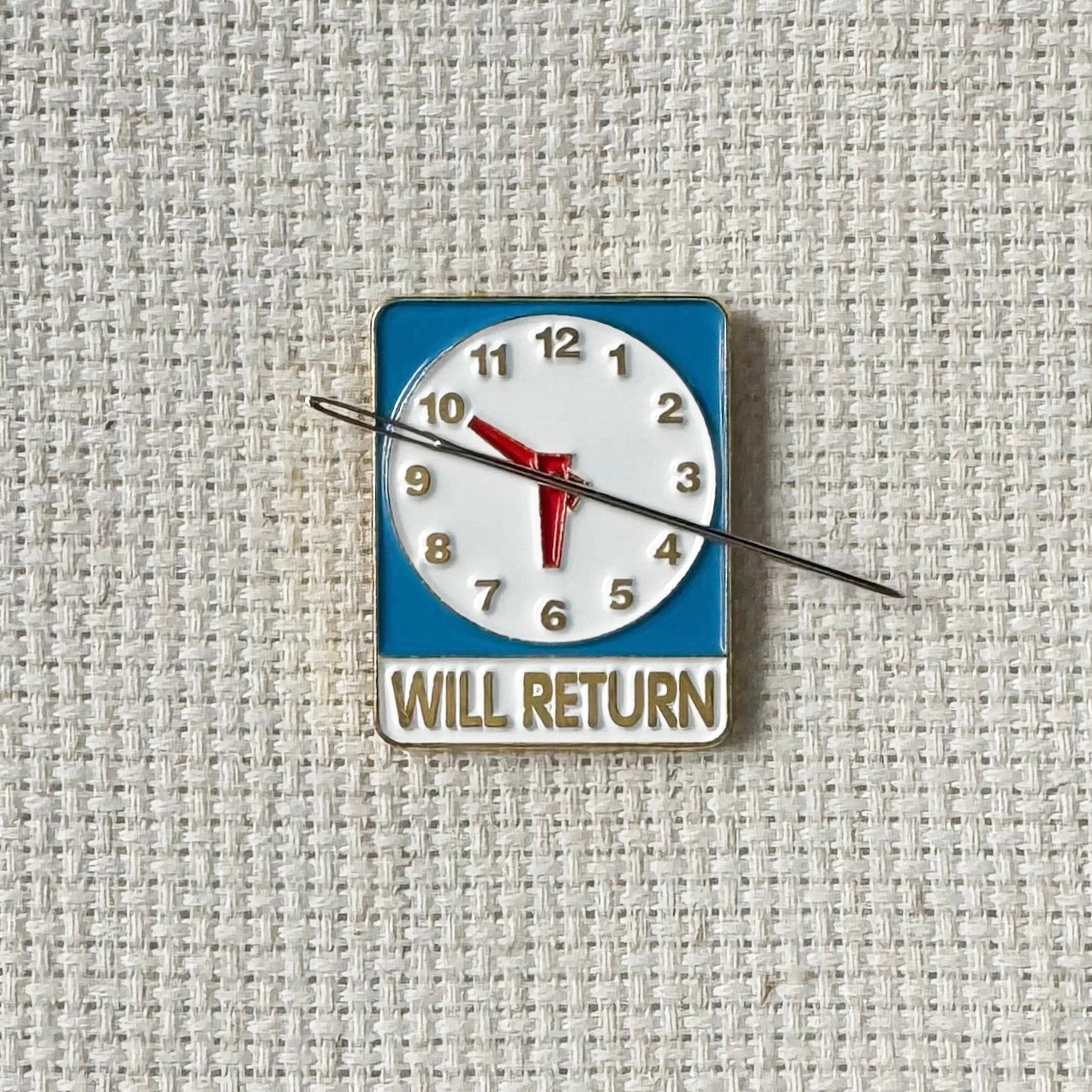 Will Return clock sign magnetic enamel needle minder – a fun and nostalgic stitching accessory for cross stitch, embroidery, sewing, quilting, or needlepoint. Perfect for adding a touch of retro charm to your project.