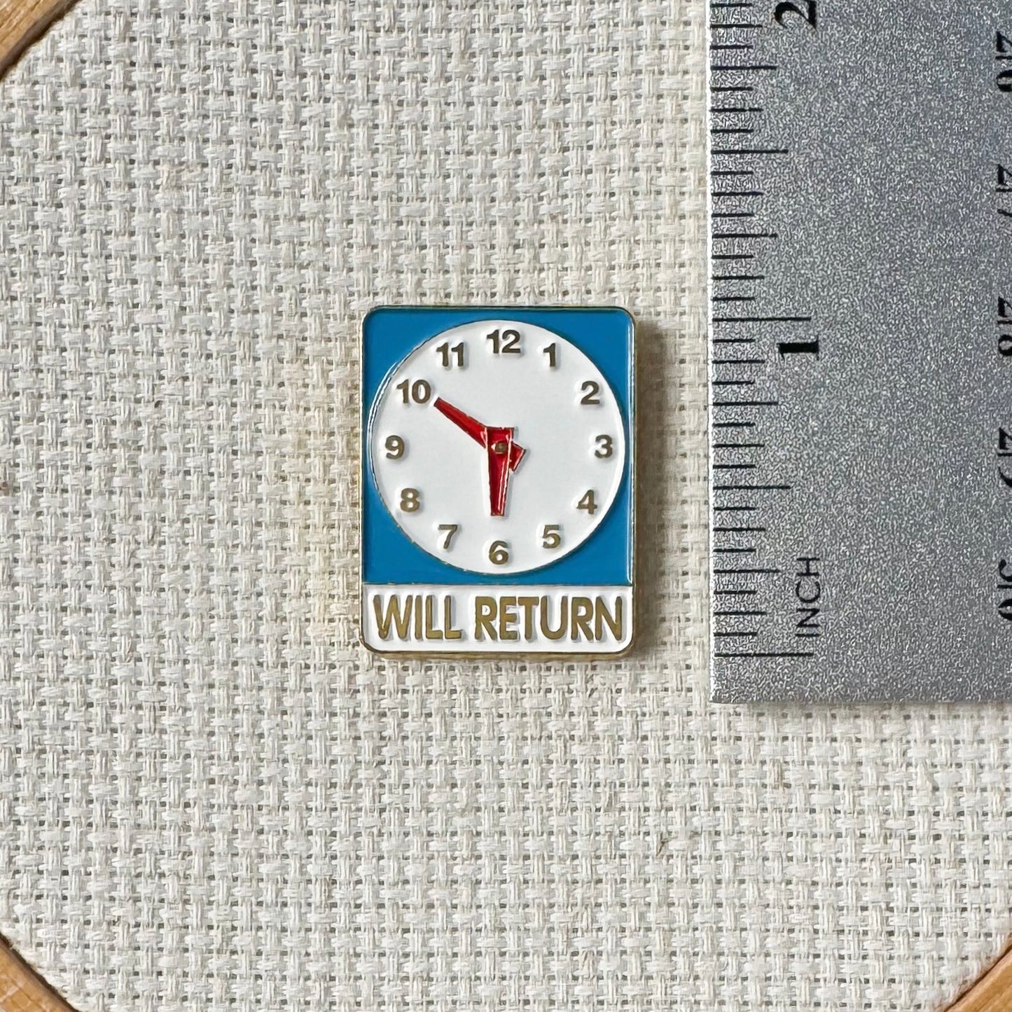 Will Return clock sign magnetic enamel needle minder – a fun and nostalgic stitching accessory for cross stitch, embroidery, sewing, quilting, or needlepoint. Perfect for adding a touch of retro charm to your project.