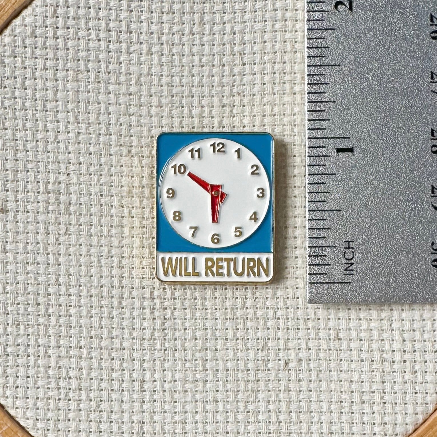 Will Return clock sign magnetic enamel needle minder – a fun and nostalgic stitching accessory for cross stitch, embroidery, sewing, quilting, or needlepoint. Perfect for adding a touch of retro charm to your project.