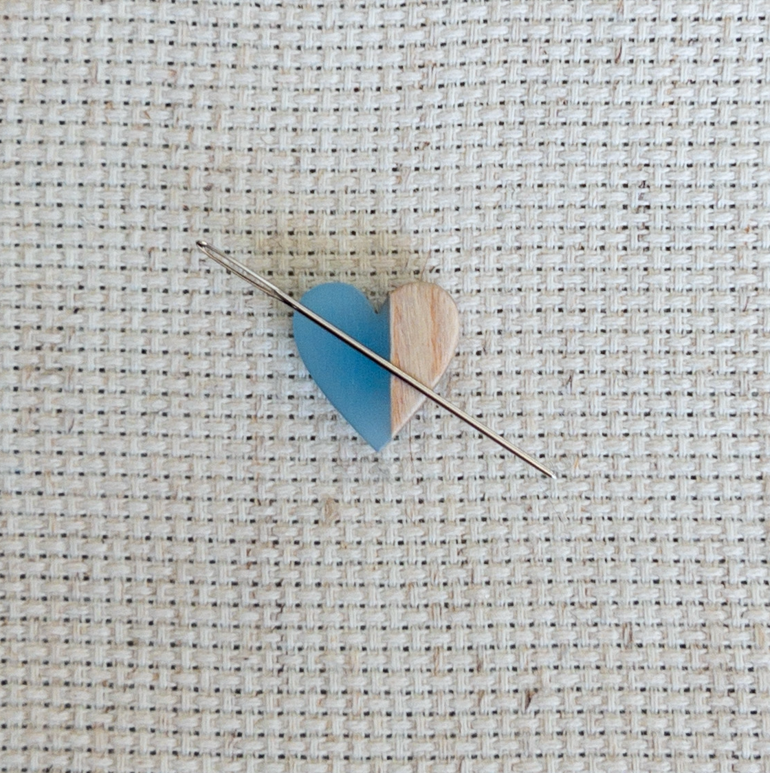 Heart shaped magnetic needle minder with blue resin and brown wood – perfect for cross stitch, embroidery, needlepoint, quilting, and hand sewing. A unique and functional needle holder for stitchers and crafters.