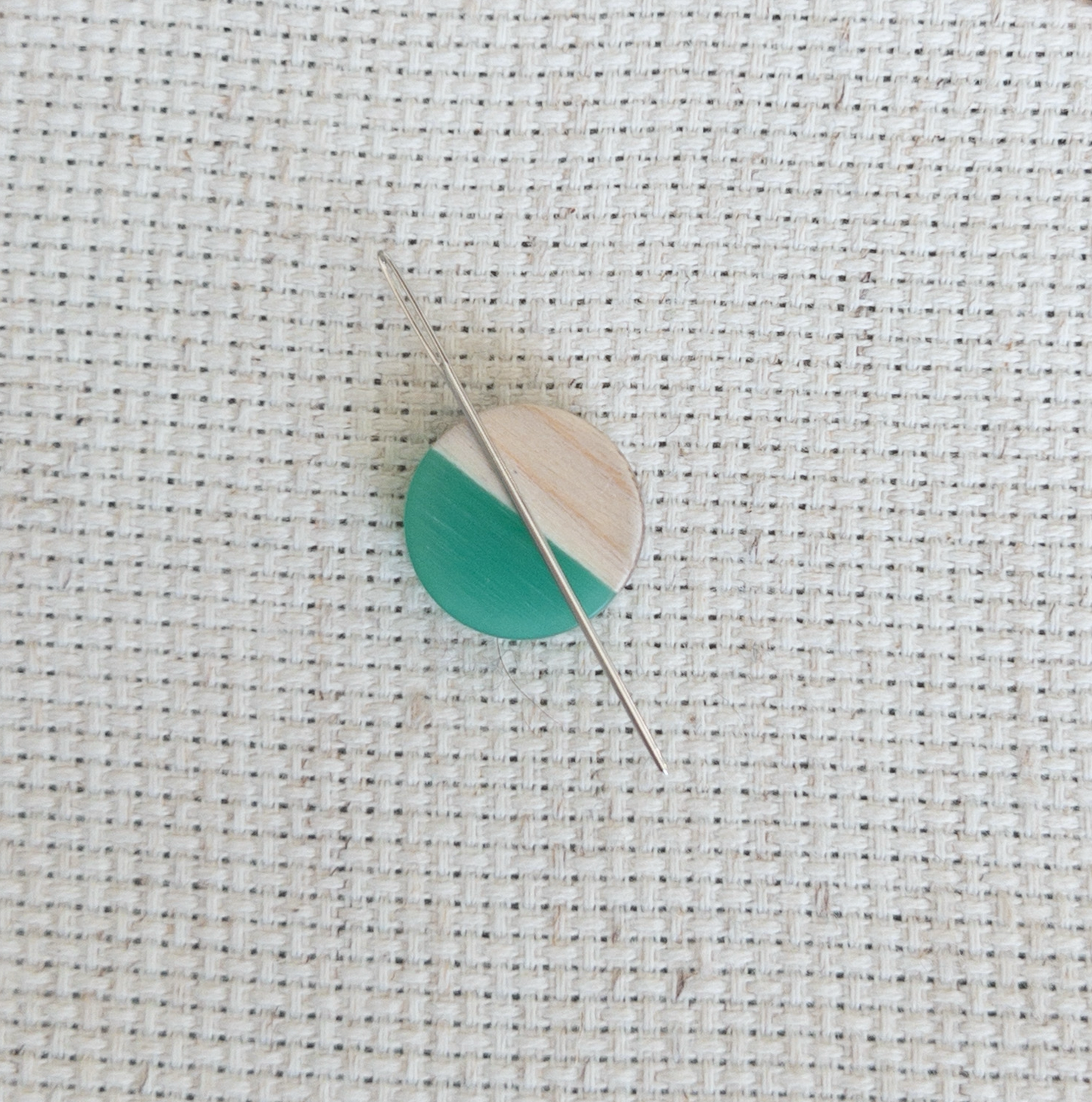 Circle shaped magnetic needle minder with green resin and natural wood – perfect for cross stitch, embroidery, needlepoint, quilting, and hand sewing. A unique and functional needle holder for stitchers and crafters.