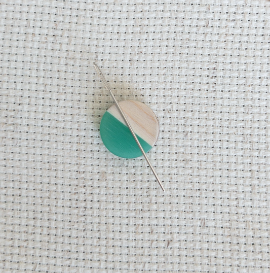 Circle shaped magnetic needle minder with green resin and natural wood – perfect for cross stitch, embroidery, needlepoint, quilting, and hand sewing. A unique and functional needle holder for stitchers and crafters.