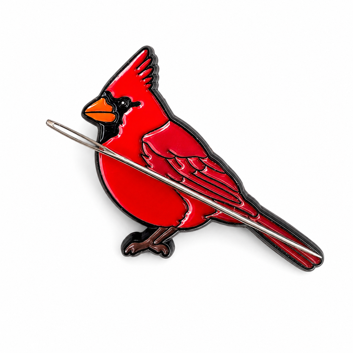 Close up of cardinal enamel needle minder with soft enamel finish and metal edging.
