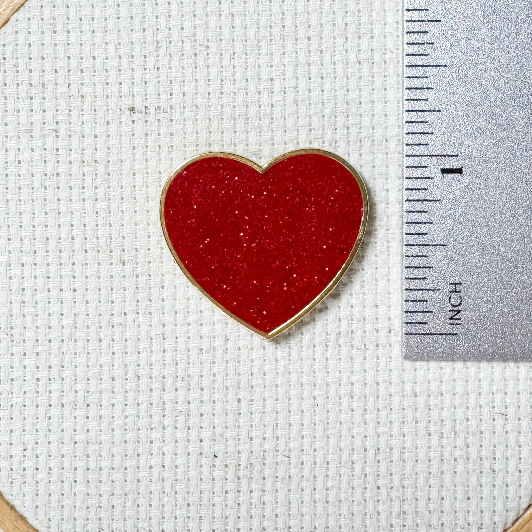 Red glitter heart shaped magnetic enamel needle minder for cross stitch, embroidery, needlepoint and sewing projects.