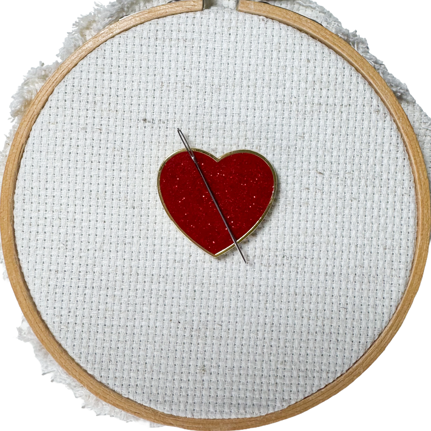 Red glitter heart shaped magnetic enamel needle minder for cross stitch, embroidery, needlepoint and sewing projects.