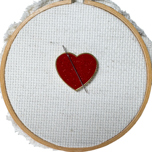Red glitter heart shaped magnetic enamel needle minder for cross stitch, embroidery, needlepoint and sewing projects.