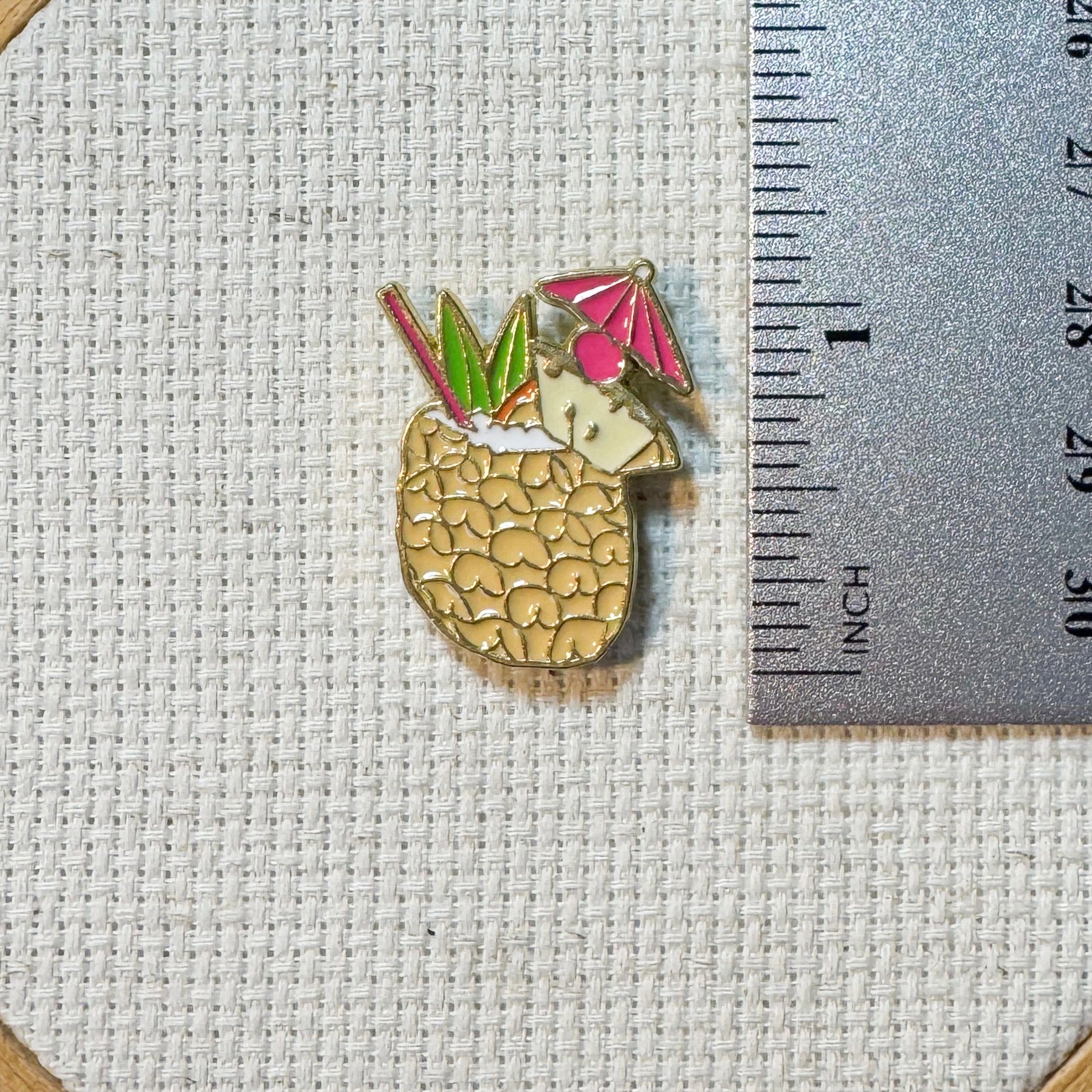 Colorful pineapple colada cocktail enamel needle minder with strong magnet, perfect for holding needles while cross stitching, embroidery, quilting, needlepoint or sewing. Fun drink themed needle holder for stitchers.