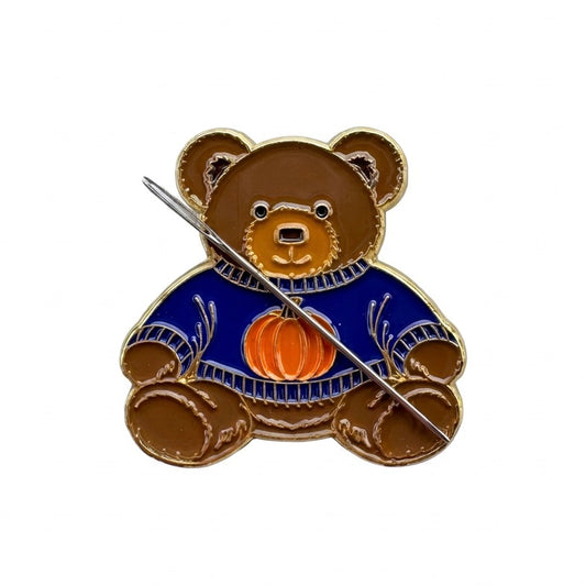 Teddy bear enamel needle minder wearing a blue sweater with a pumpkin, magnetic needle holder for cross stitch, needlepoint, embroidery, quilting, sewing and other stitching projects.