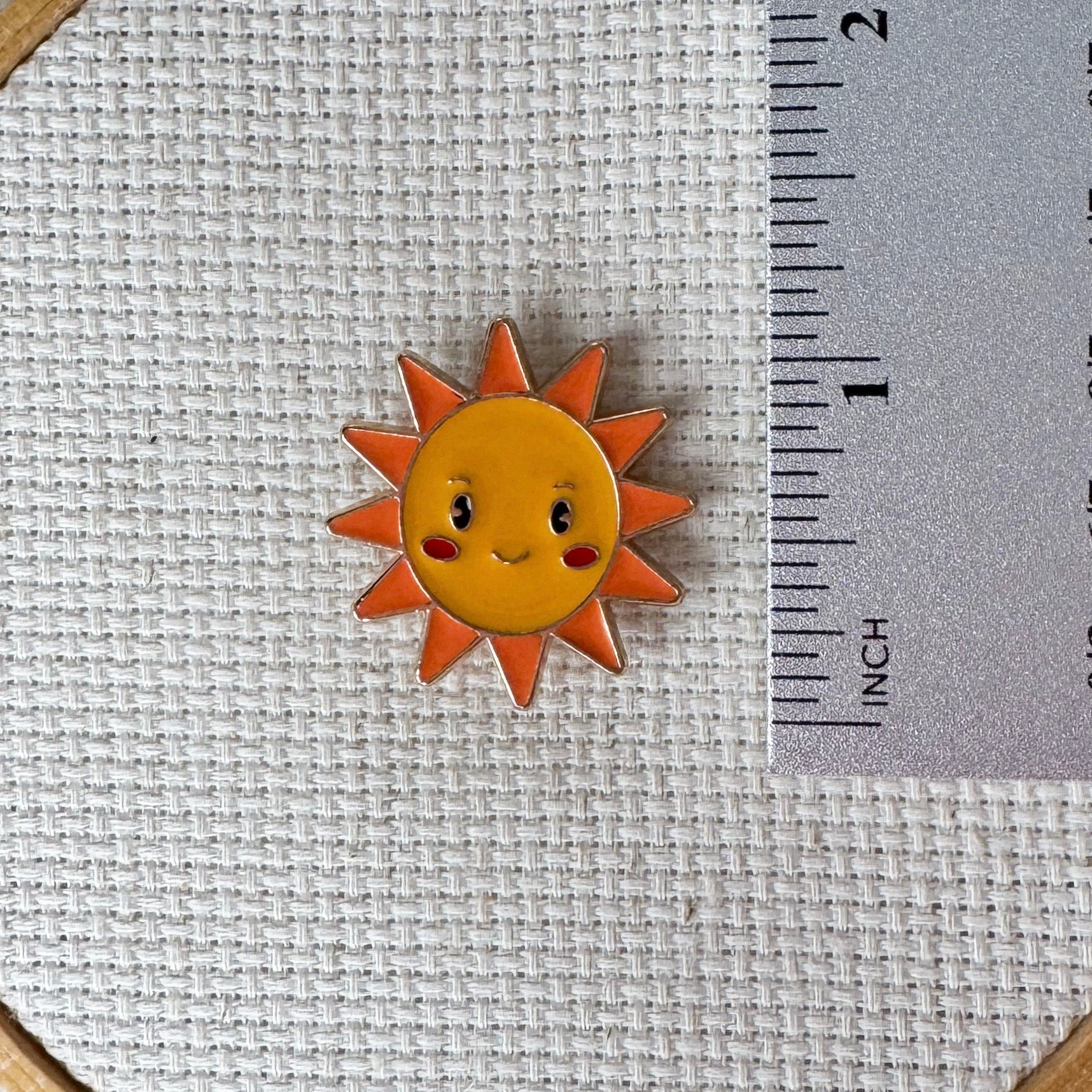 Happy sun face magnetic needle minder – cheerful enamel accessory for cross stitch, embroidery, and needlepoint – cute summer stitching gift for sunshine lovers.