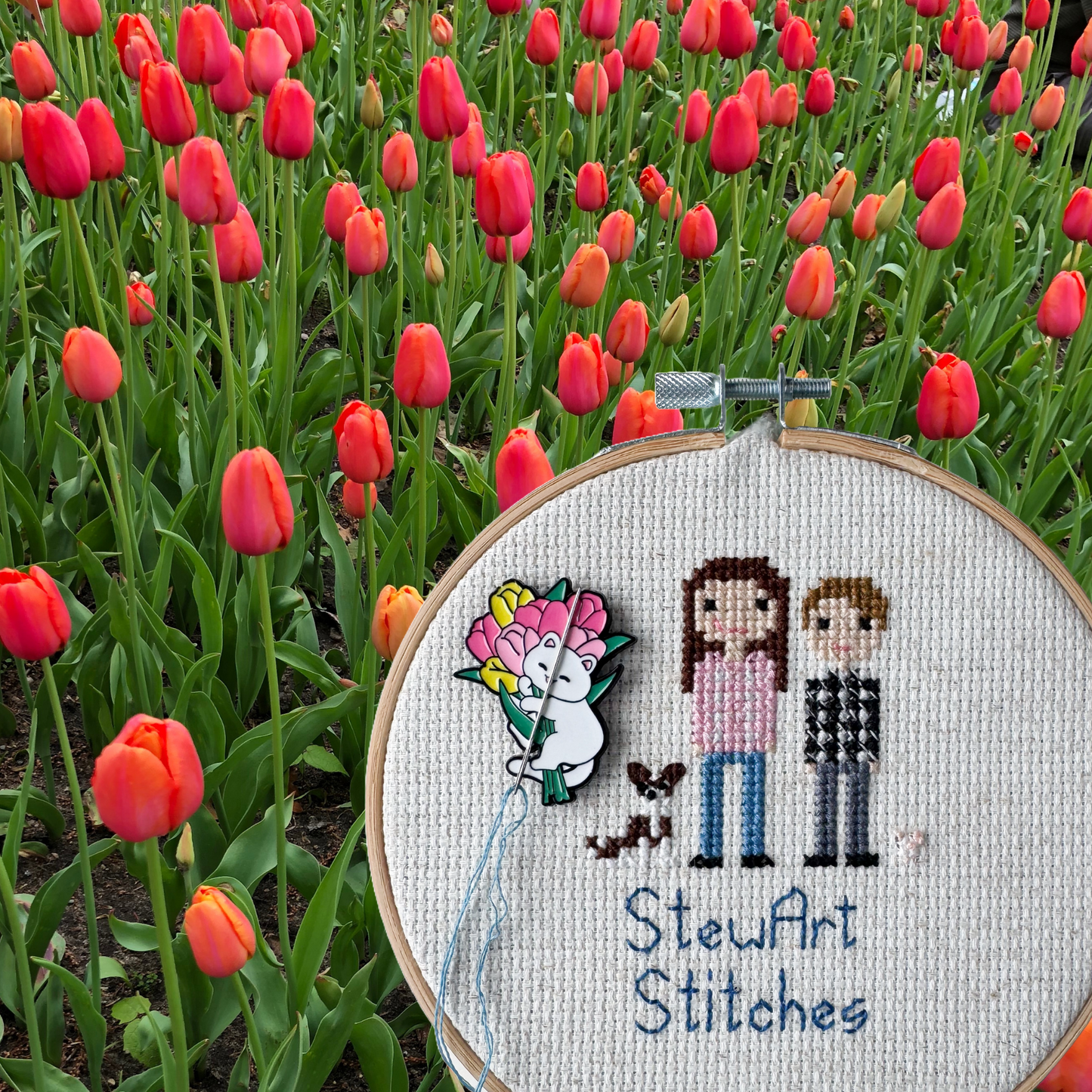 White cat holding pink and yellow tulips needle minder – magnetic enamel holder for cross stitch, embroidery, needlepoint or sewing.