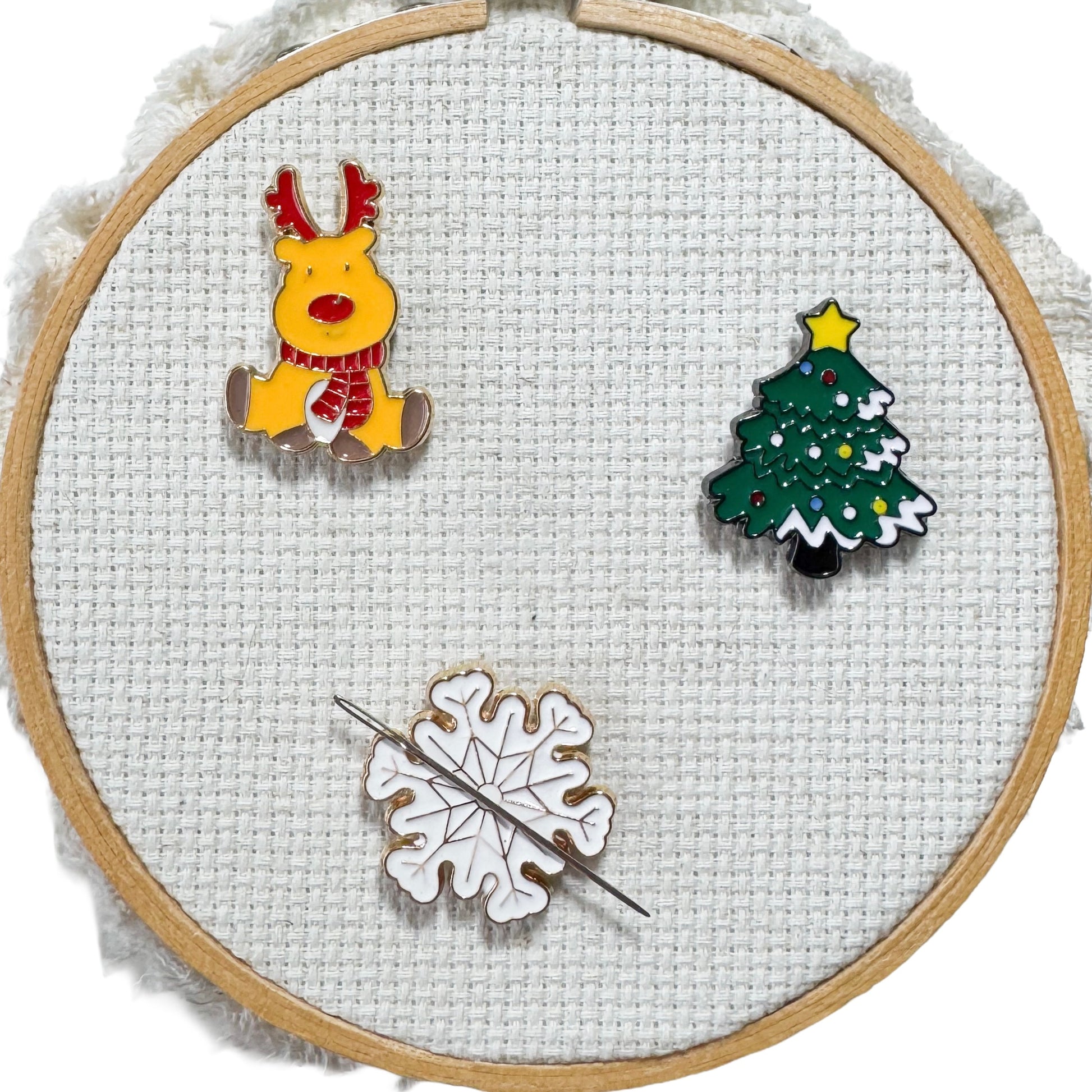 Bring some holiday cheer to your stitching with these festive winter magnetic enamel needle minders! Choose from a snowflake, Christmas tree, reindeer—or grab the whole festive set!